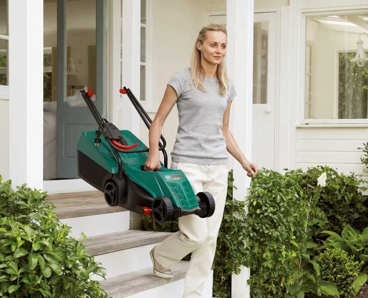 Ragazza porta in giardino il tagliaerba