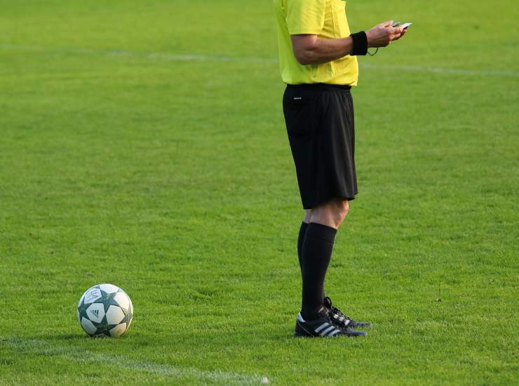 Un arbitro con il pallone in campo