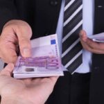 uomo poggia banconote euro su una mano come simbolo della cessione del quinto