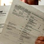 Una signora legge la bolletta