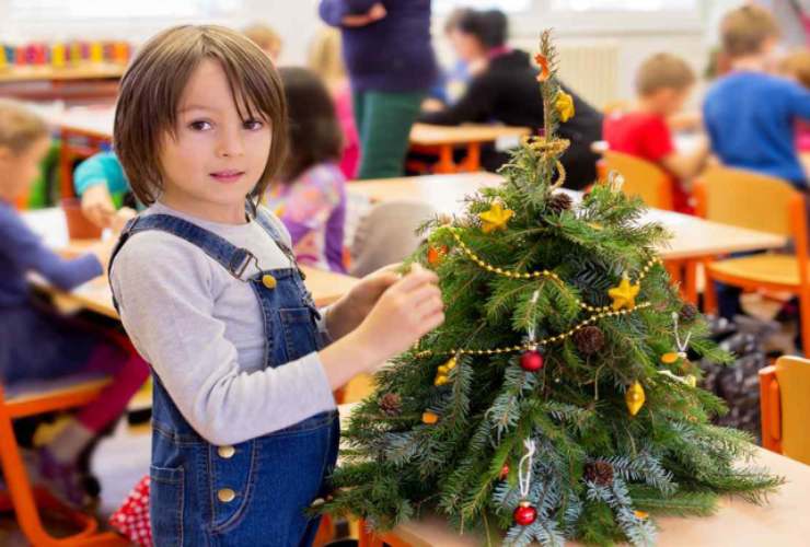 Un alunno prepara l'albero di Natale in classe