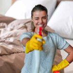 Letto e donna con spruzzino