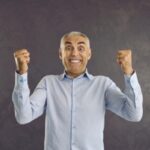 uomo che esulta con i pugni stretti