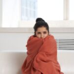 donna sul divano avvolta in una coperta