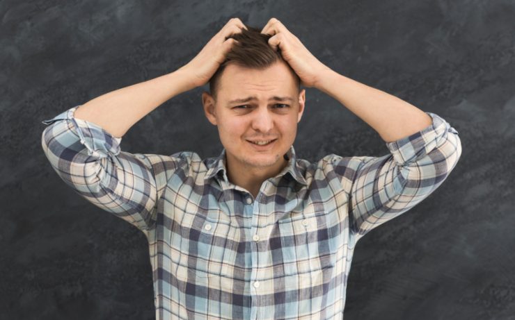 uomo preoccupato con le mani nei capelli