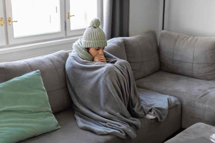 Donna infreddolita sul divano