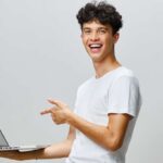 ragazzo sorridente con pc portatile in mano