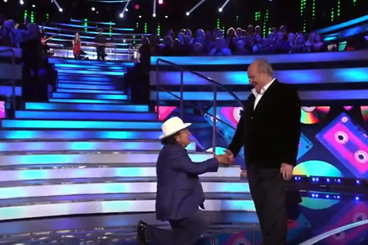 al bano si inginocchia per salutare gerry scotti a la ruota dei campioni