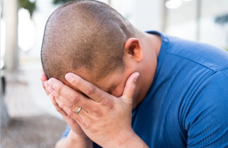 uomo disperato con le mani in faccia