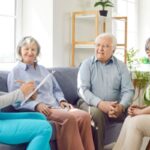 anziani seduti sul divano con la badante