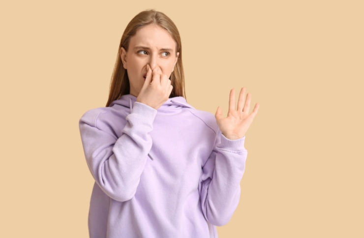 donna che si tappa il naso con le dita