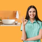 donna che sorride e fa ok con le dita e dietro di lei l'immagine di un bagno