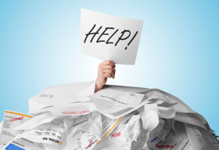 mano con in mano un cartello con la scritta aiuto sotto una montagna di cartelle esattoriali