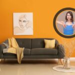 divano tavolino e quadro alla parete e donna con i pollici rivolti verso il basso