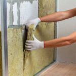 operaio che installa i pannelli isolanti all'interno dell'appartamento