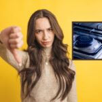 donna con il pollice verso il basso e fornelli a gas