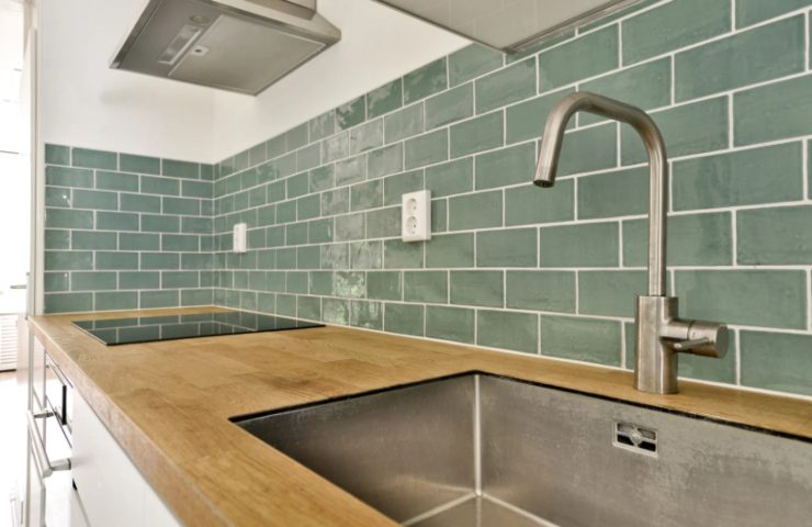 piastrelle verdi dietro al lavandino della cucina