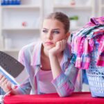 donna con ferro da stiro in mano ed espressione triste