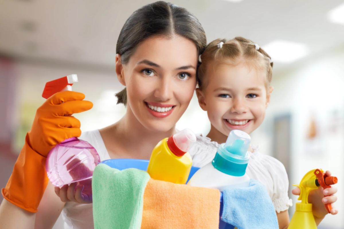 mamma e bambina che sorridono con dei detersivi in mano per fare le pulizie