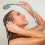 donna che sorride sotto la doccia