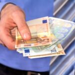 uomo che porge delle banconote a qualcuno