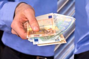 uomo che porge delle banconote a qualcuno