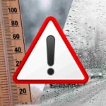 immagini di maltempo, un termometro e un simbolo di pericolo