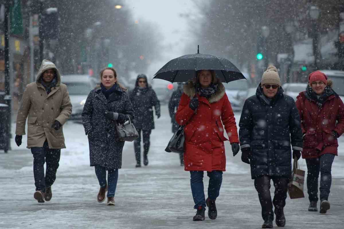 persone camminano sotto pioggia e neve