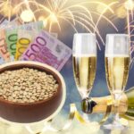 sfondo fuochi d'artificio, bicchieri e spumante, ciotola lenticchie con banconote euro