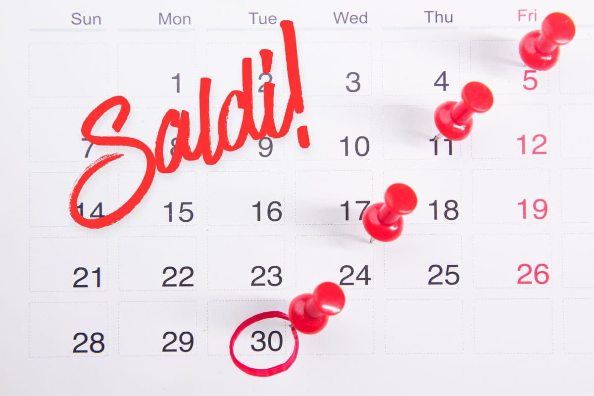 calendario con puntine che segnano giorni e scritta "saldi!"