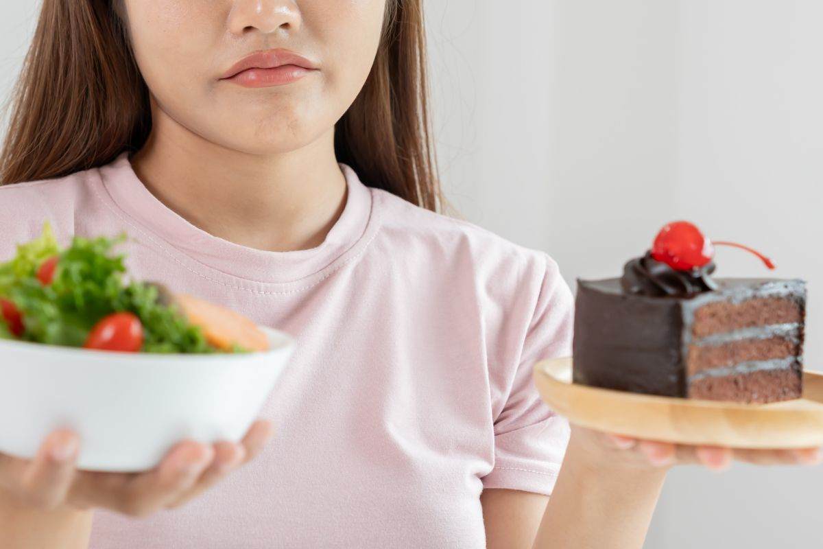 Ragazza a dieta indecisa sul pasto