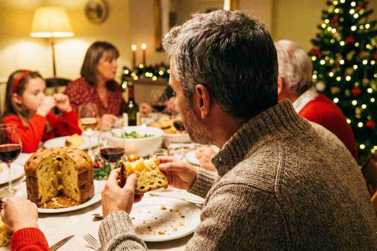 Un uomo mangia il panettone