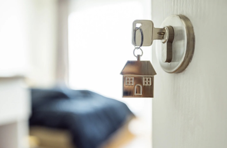 chiave dentro ad una porta aperta e sullo sfondo un letto