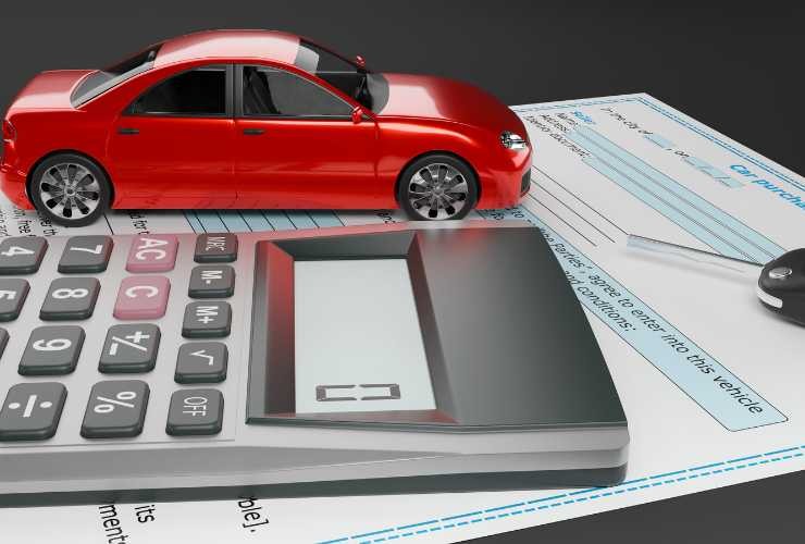 documento, calcolatrice e auto in miniatura