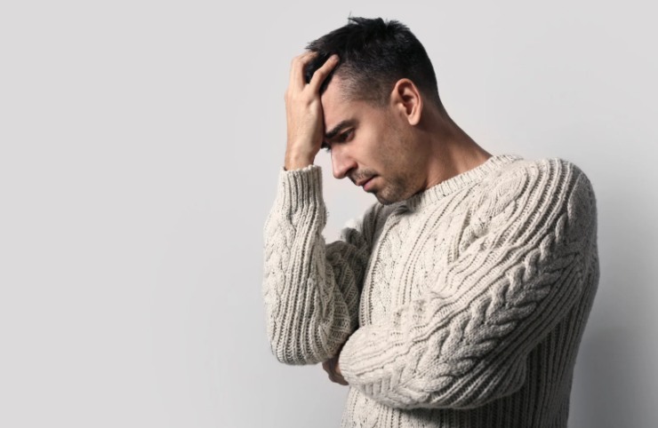 uomo disperato con una mano sulla fronte