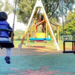 bambino sull'altalena al parco giochi