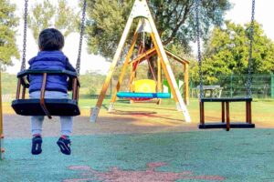 bambino sull'altalena al parco giochi