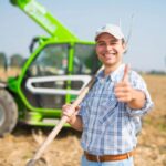 uomo in mezzo ad un campo con il pollice verso l'alto