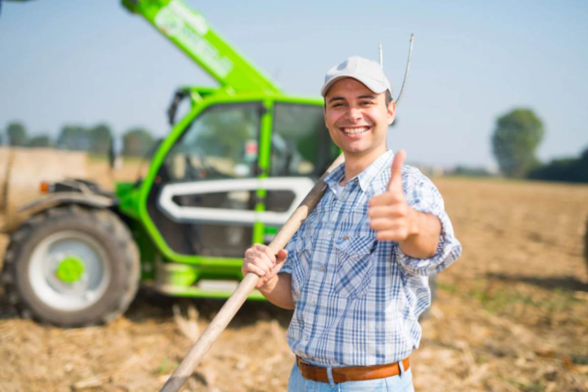 uomo in mezzo ad un campo con il pollice verso l'alto