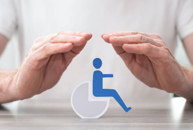 simbolo disabilità coperto con le mani