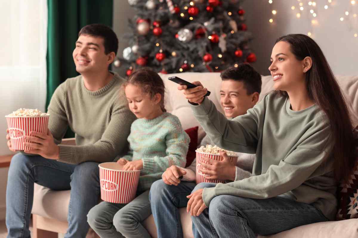 famiglia guarda tv albero di natale pop corn