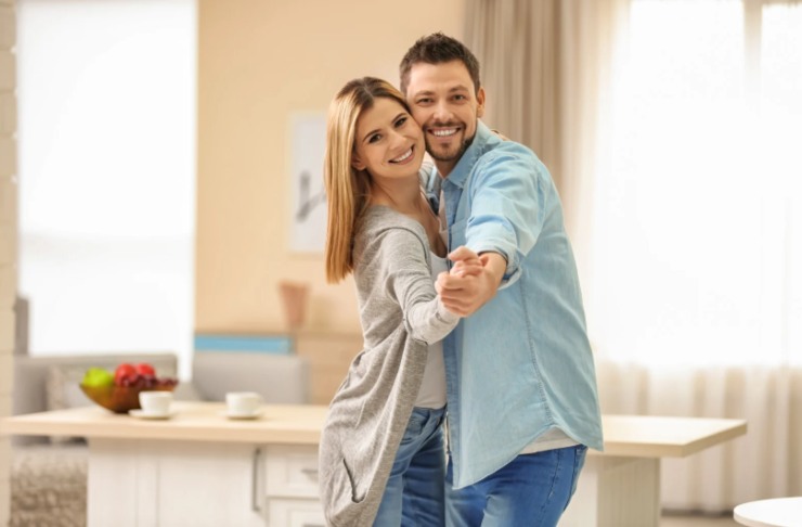 uomo e donna felici che ballano in casa