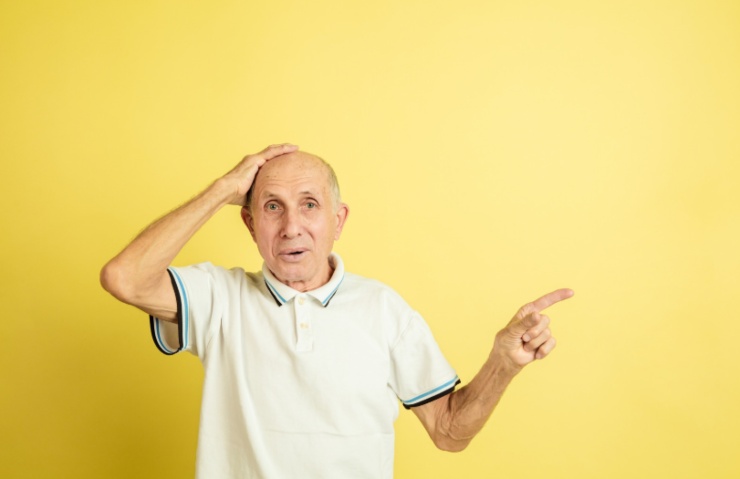 uomo anziano preoccupato con una mano sulla testa