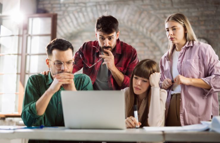 gruppo di giovani preoccupati davanti ad un computer