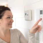 donna che regola termostato