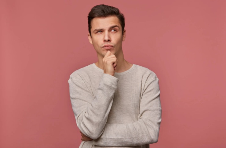 uomo con espressione dubbiosa che si tocca il mento 