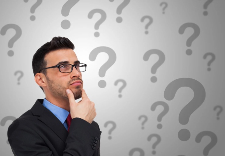 giovane con espressione dubbiosa circondato da punti interrogativi
