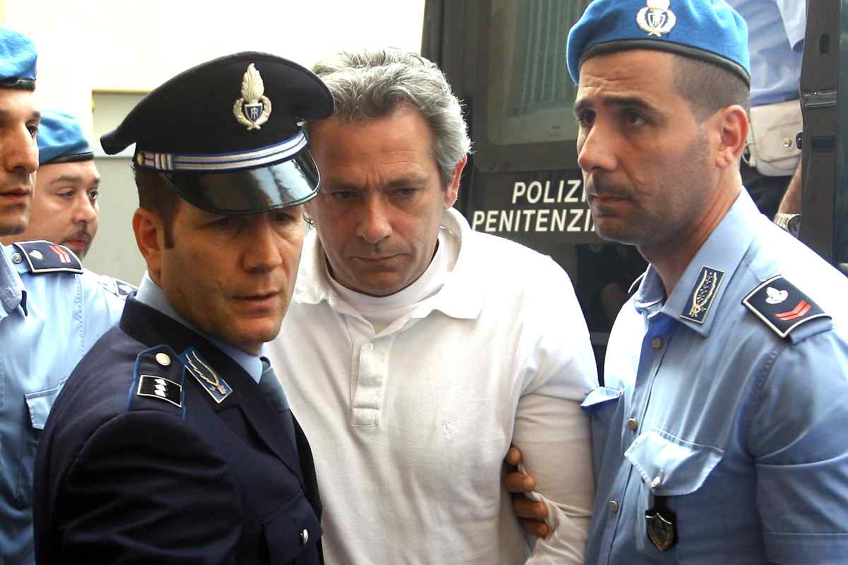 Mario Alessi cammina scortato dalle forze dell'ordine