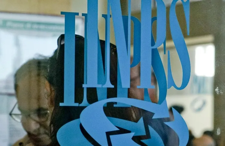 Doppio logo INPS su delle vetrate con persone sullo sfondo.