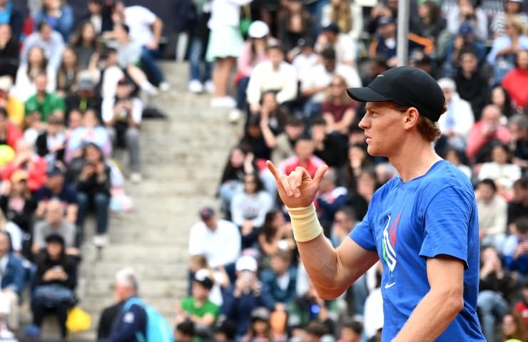 Jannik Sinner ritratto di profilo esulta col pugno destro dopo una giocata vincente.